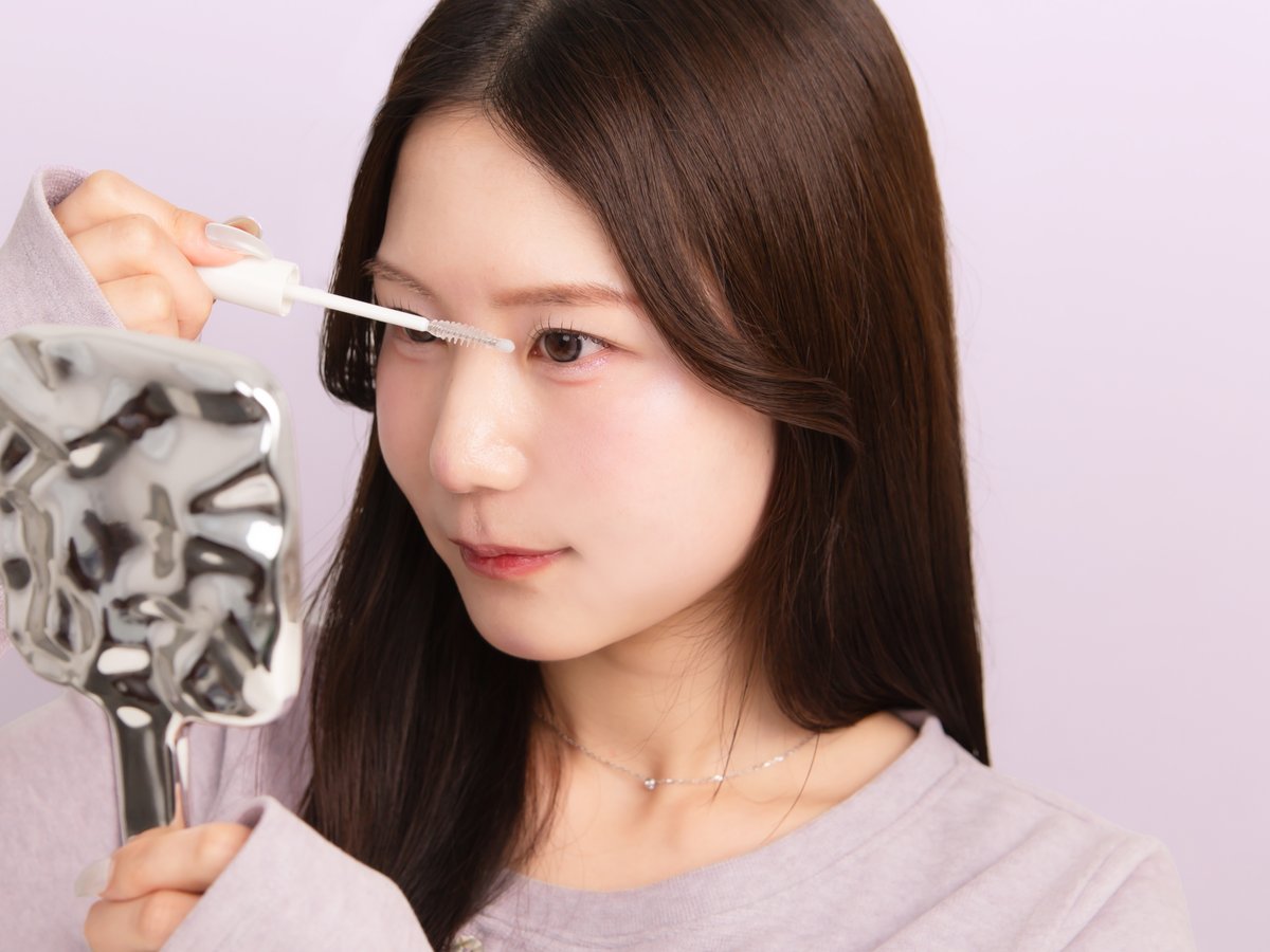 手鏡を見ながら、先端のボールで毛先を寄せているところ
